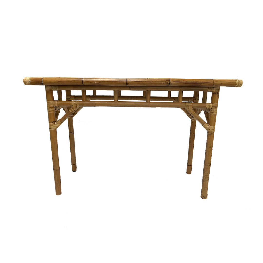 Consola en Bambú y Ratán Kalua, de forma rectangular con cuatro patas y falda decorativa de rejilla, fabricada en bambú para un diseño ecológico, mostrada sobre fondo blanco.