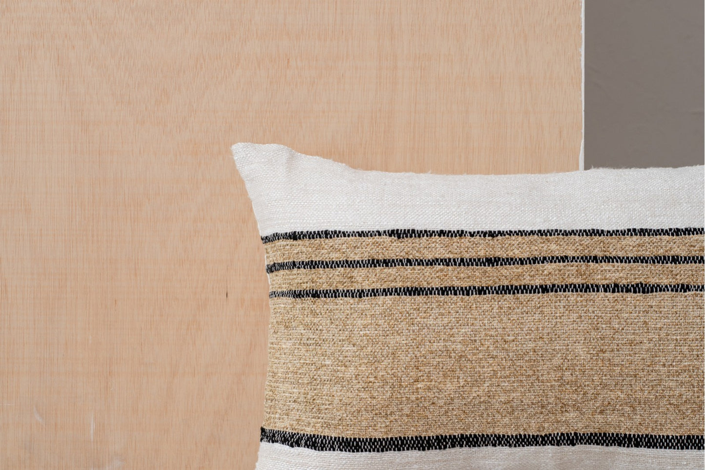 Detalle del Cojín de algodón blanco, camel con franjas negras 60x40CM - natural - ERO N2, de colores blanco y camel con franjas negras, sobre un fondo de madera clara.