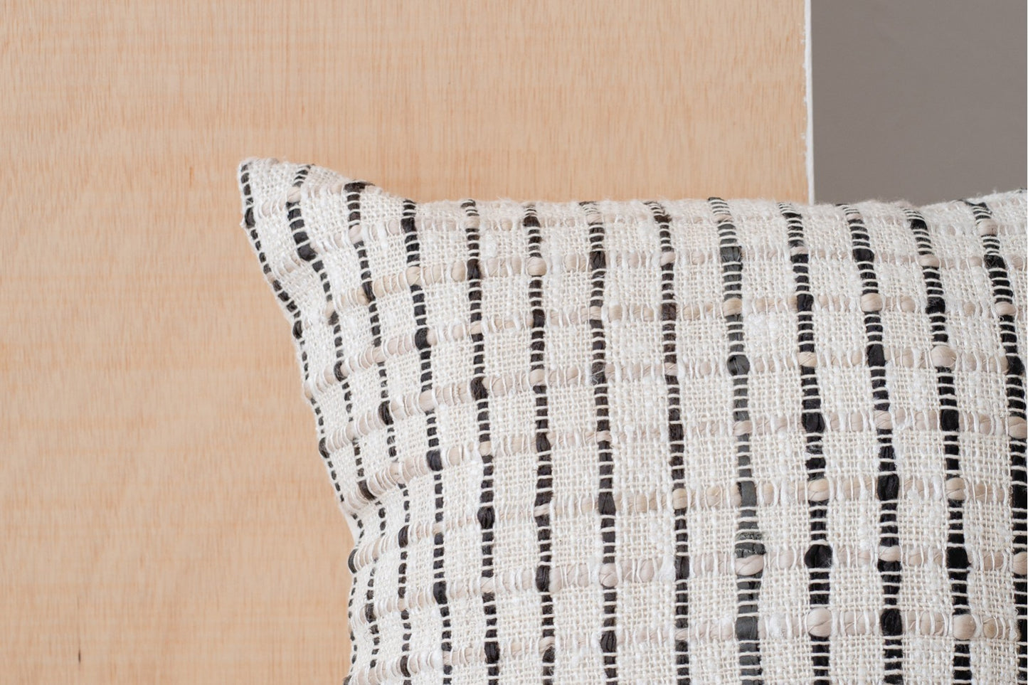 Detalle del Cojín de algodón blanco, negro y beige con cuadrícula 50X50CM - natural - OTO N4, con motivo geométrico cuadriculado, sobre fondo de madera clara.