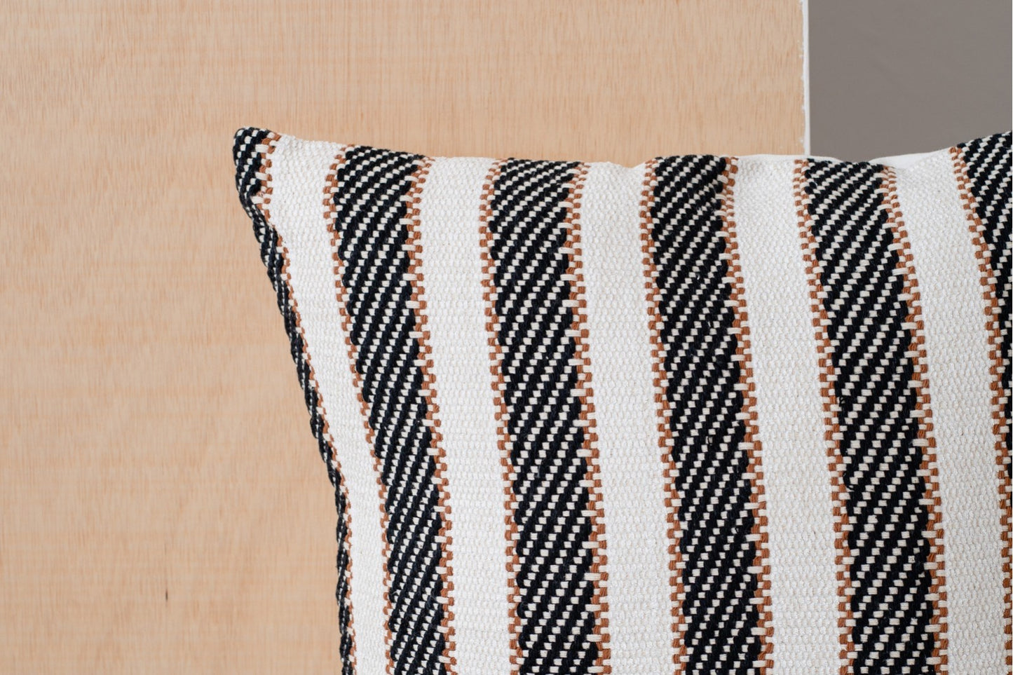 Detalle del Cojín de algodón blanco y negro con detalle terracota 50X50CM - natural - OTO N1, con detalles en blanco, negro y terracota sobre un fondo de madera clara.