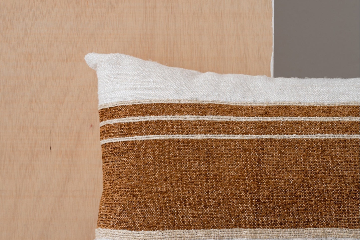 Detalle del Cojín de algodón blanco, beige y ocre con franjas - natural - MINIA N4 sobre un fondo de madera y gris, perfecto para la decoración del hogar.