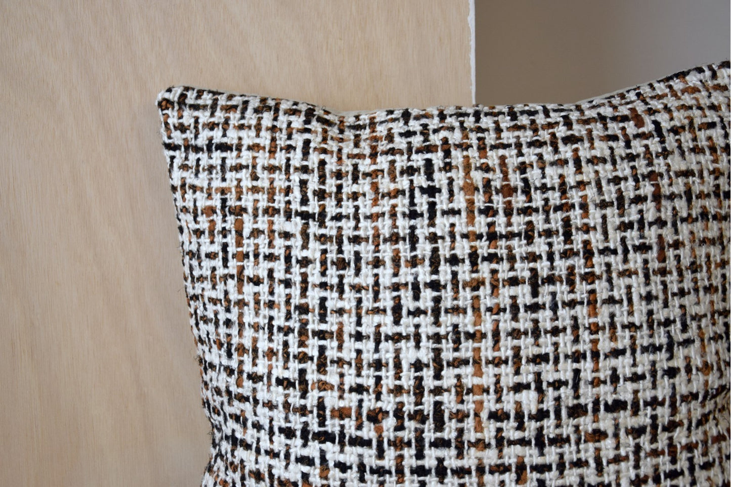 Detalle del Cojín de algodón ocre, mostaza y blanco con cuadrícula 50x50CM LAZA N5, con un diseño tejido texturizado, sobre un fondo de madera clara. Ideal para añadir un toque de diseño contemporáneo a cualquier espacio.