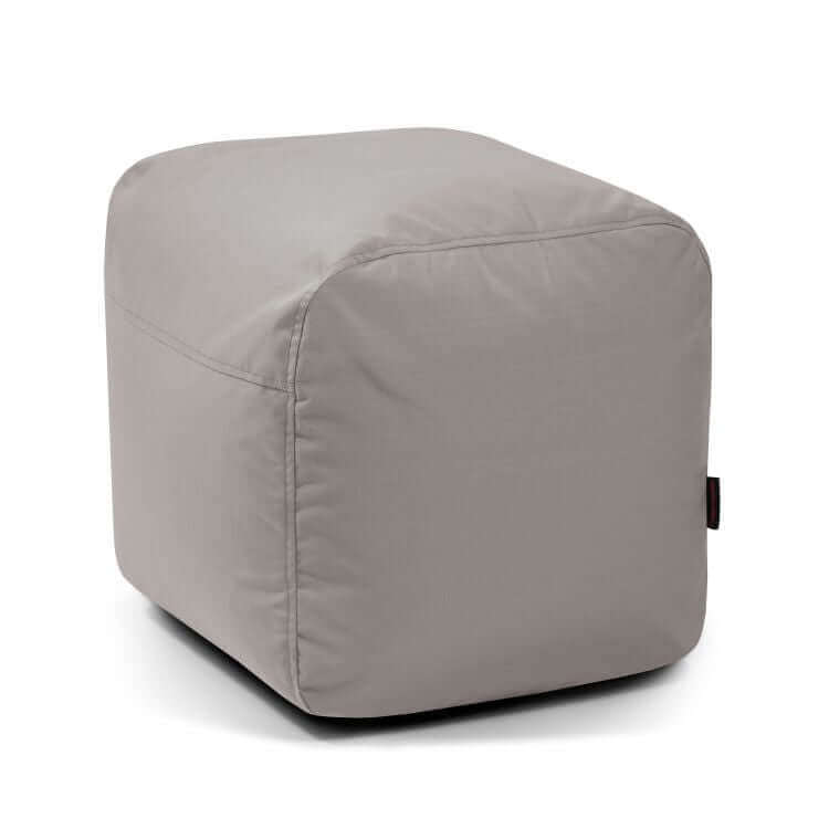 Una otomana cúbica Pouf Plus 50 Colorin de color gris claro recubierta de tela con costuras visibles, diseñada para uso en exteriores como asiento cómodo, mostrada sobre un fondo blanco liso.
