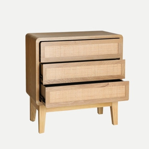 La cómoda en madera de abeto DOAZIT tiene tres cajones abiertos con diseño de ratán tejido al frente, ideal para aportar un toque nórdico y contemporáneo a cualquier espacio.