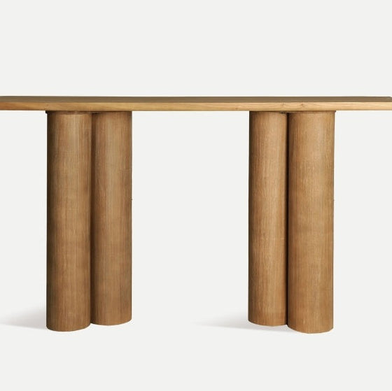 La Consola en madera DM Hoek presenta una tapa rectangular y cuatro patas cilíndricas gruesas, combinando funcionalidad y estilo para complementar la estética moderna de cualquier espacio.