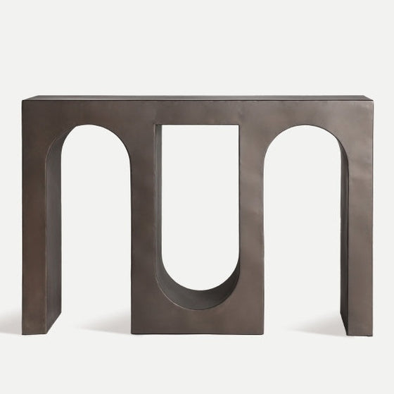 La Consola en hierro Industrial Rethel presenta un acabado oscuro mate y tres recortes arqueados, fusionando diseño geométrico y moderno con estilo industrial para un mueble contemporáneo llamativo.