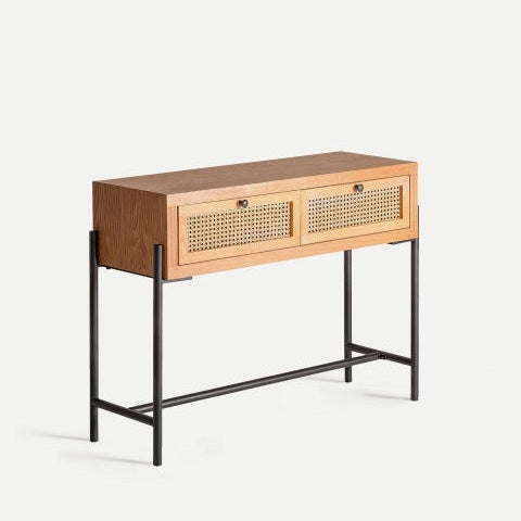 La Consola en DM y ratán Zetel, de diseño contemporáneo con dos cajones de entramado de ratán y estructura de metal negro, destaca sobre un fondo claro.