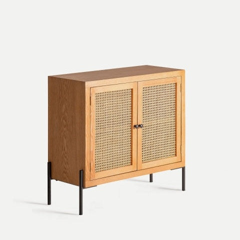 Aparador en DM y ratán Zetel S: pequeño gabinete moderno con dos puertas de ratán tejido y patas de metal negro, fotografiado sobre fondo claro.