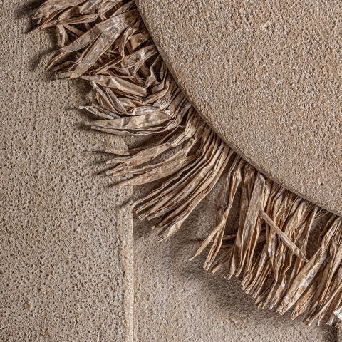 Primer plano de una pared texturizada de color beige con un detalle decorativo circular bordeado de plantas secas con flecos, evocando diseño moderno, arte y calidad, similar al Cuadro decorativo en DM con relieve (80x120 cm) Winterberg.