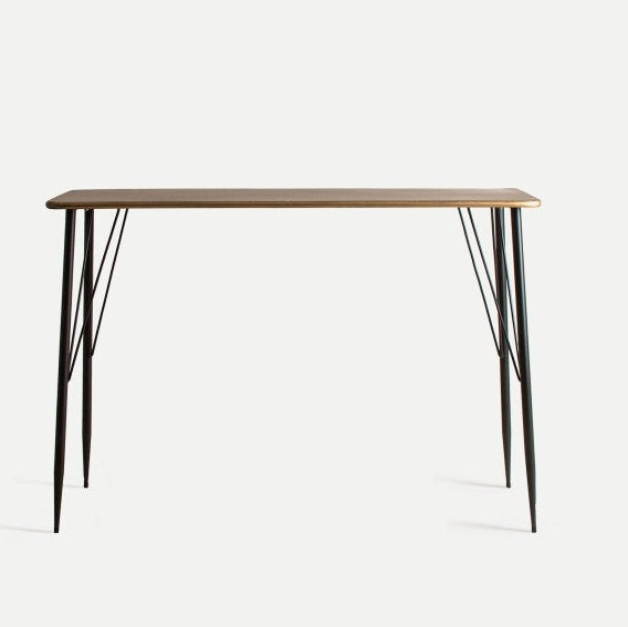El escritorio Reken en hierro y acabado envejecido tiene un diseño elegante y funcional, con tapa rectangular y cuatro patas metálicas esbeltas, mostrado sobre fondo blanco.