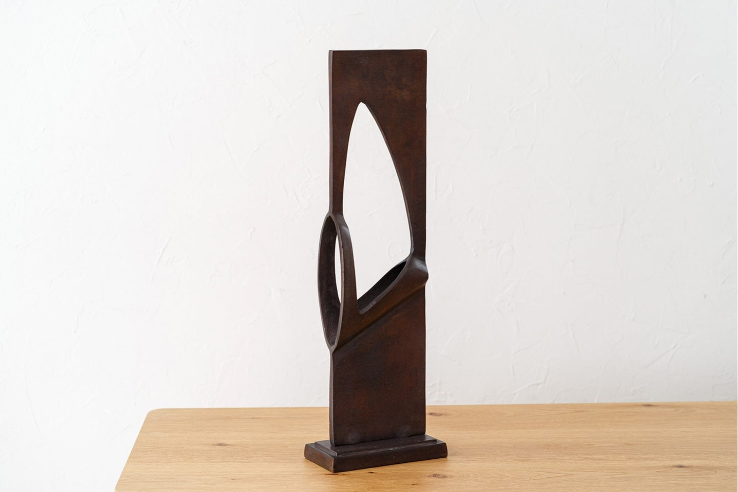 Escultura abstracta de metal con acabado óxido envejecido - moderna - DOOR, con diseño angular y curvas, sobre madera clara frente a pared blanca; perfecta para decoración moderna.