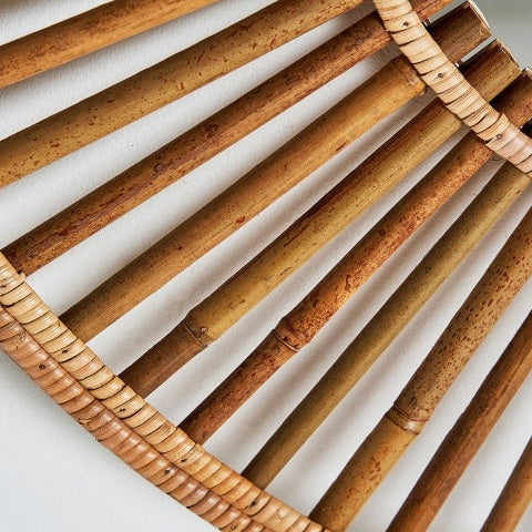 Primer plano del Espejo redondo de bambú natural (90 cm) Arteaga, que presenta varillas de bambú alineadas verticalmente y tiras de ratán horizontales, resaltando su diseño moderno sobre un fondo blanco.