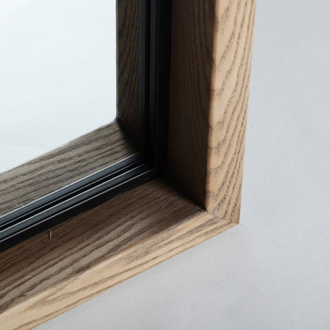 Primer plano de un marco de ventana de madera con veta visible y vidrio, capturado en ángulo para resaltar la esquina—ideal para decoración del hogar con estilo minimalista, en línea con el Espejo de pie en madera de fresno Busk.