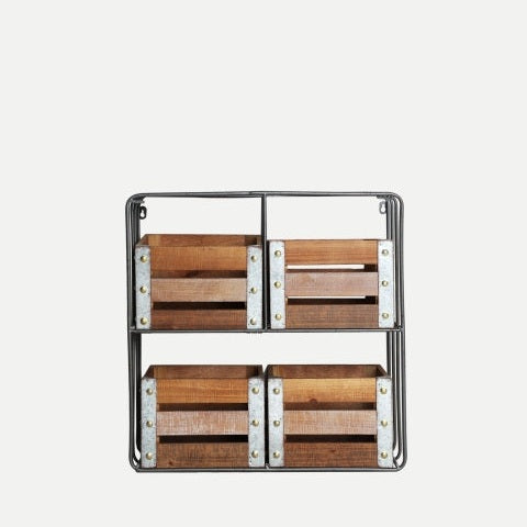 La Estantería de hierro y madera DM Yeovil es una estantería de metal negro con cuatro compartimentos de madera DM envejecida, que presenta esquinas metálicas de estilo industrial, dispuestas en dos filas sobre un fondo liso.