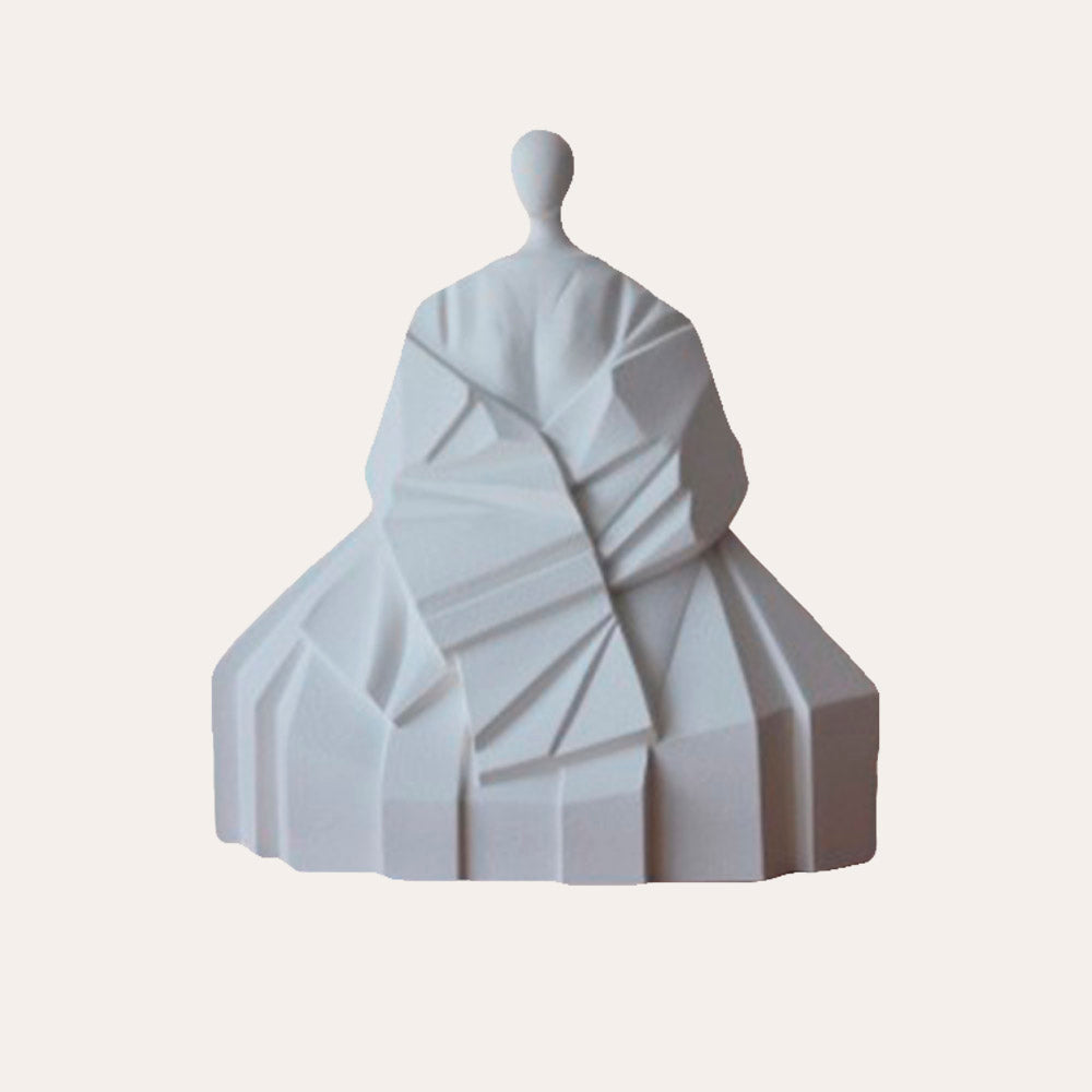 Una escultura blanca de una mujer con vestido.