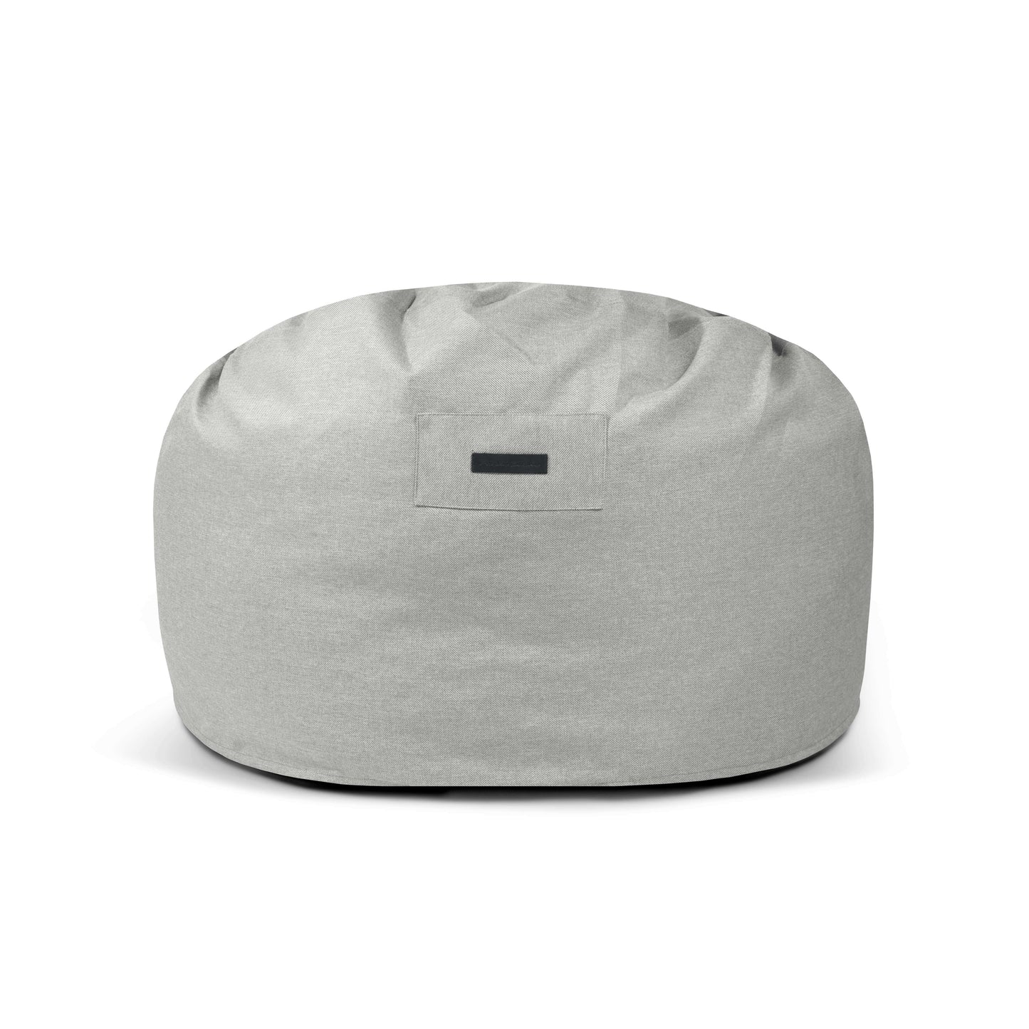 El Foam Bean Bag OM 110 Riviera para uso exterior es una silla redonda de color gris claro con una etiqueta frontal rectangular negra, que proporciona un asiento cómodo sobre un fondo blanco liso.