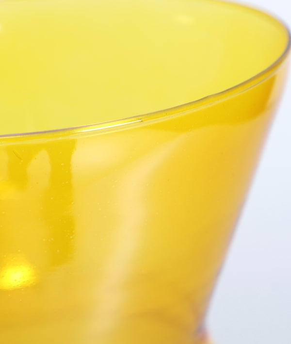 Primer plano del borde superior de un jarrón de cristal morado translúcido (18×18×37 cm), OSSIAN, sobre un fondo claro, que evoca el encanto de la decoración artesanal.