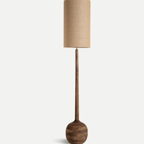La Lámpara de pie en madera minimalista Glogow tiene base redonda de madera de mango, tallo delgado y pantalla cilíndrica beige, ideal para complementar espacios modernos con fondos neutros.