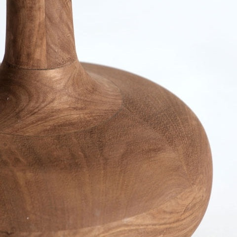 Primer plano de la base y el tallo inferior de la lámpara de mesa en madera de mango Glogow S, que presenta una madera suave de color marrón claro con patrones de vetas visibles, sobre un fondo blanco liso.