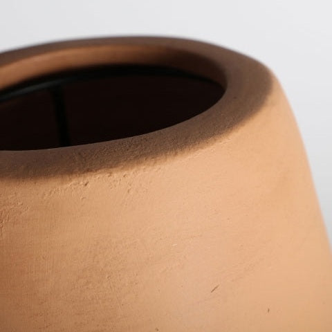 Primer plano del borde y la parte superior de la Lámpara de mesa en terracota y latón Swahili B en terracota marrón claro con diseño clásico, sobre un fondo liso.