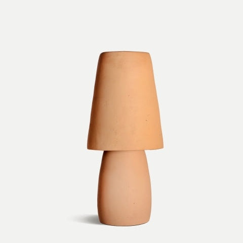 La lámpara de mesa en terracota y latón Swahili B destaca por su diseño minimalista, base cilíndrica y pantalla cónica a juego, ideal para quienes buscan iluminación decorativa con estilo clásico.