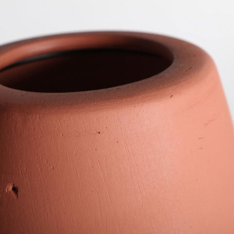 Primer plano del borde y la parte superior de la Lámpara de mesa en terracota coral Swahili C, que muestra un diseño contemporáneo sobre un fondo liso.