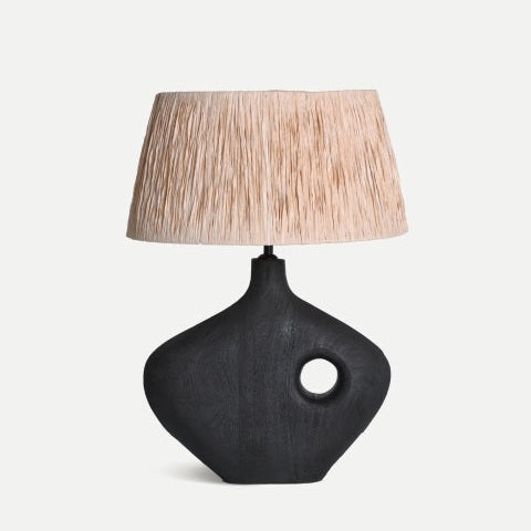 La lámpara de mesa Mangar combina una base de madera de mango con un diseño contemporáneo y pantalla texturizada en rafia, aportando un toque escultórico y elegante a tu espacio.