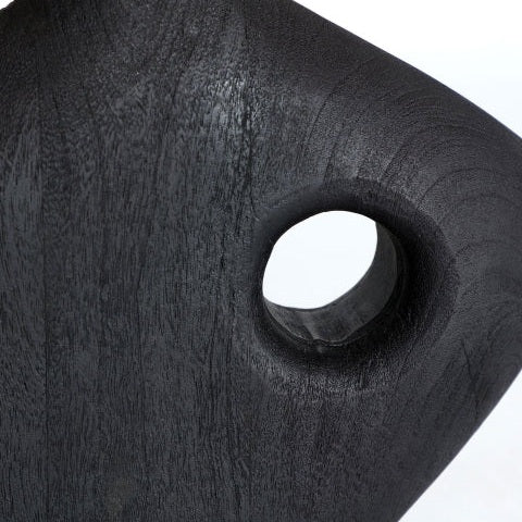 Primer plano de una lámpara de mesa lisa y oscura en madera de mango y rafia Mangar con un orificio circular cerca del centro y una textura de veta de madera visible, que resalta su diseño contemporáneo.