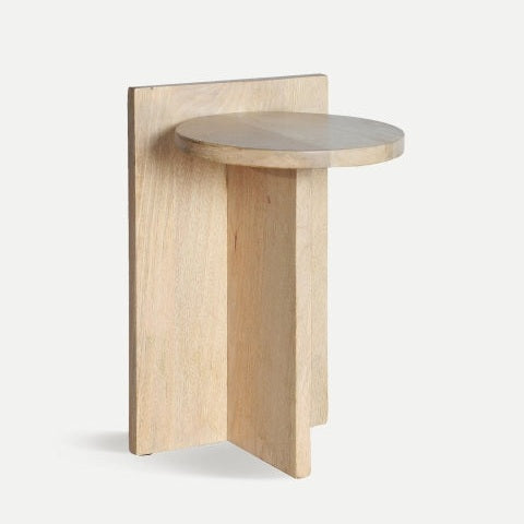 Una mesa auxiliar de tapa redonda llamada "Mesa auxiliar en madera de mango Leszno", que presenta un elegante diseño de base geométrico.