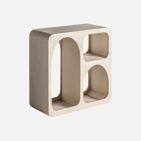 El estante en madera de mango Kotka, de forma rectangular y color beige, tiene tres compartimentos (arco alto, cuadrado pequeño y rectangular mediano) con bordes redondeados y diseño asimétrico para un estilo contemporáneo.