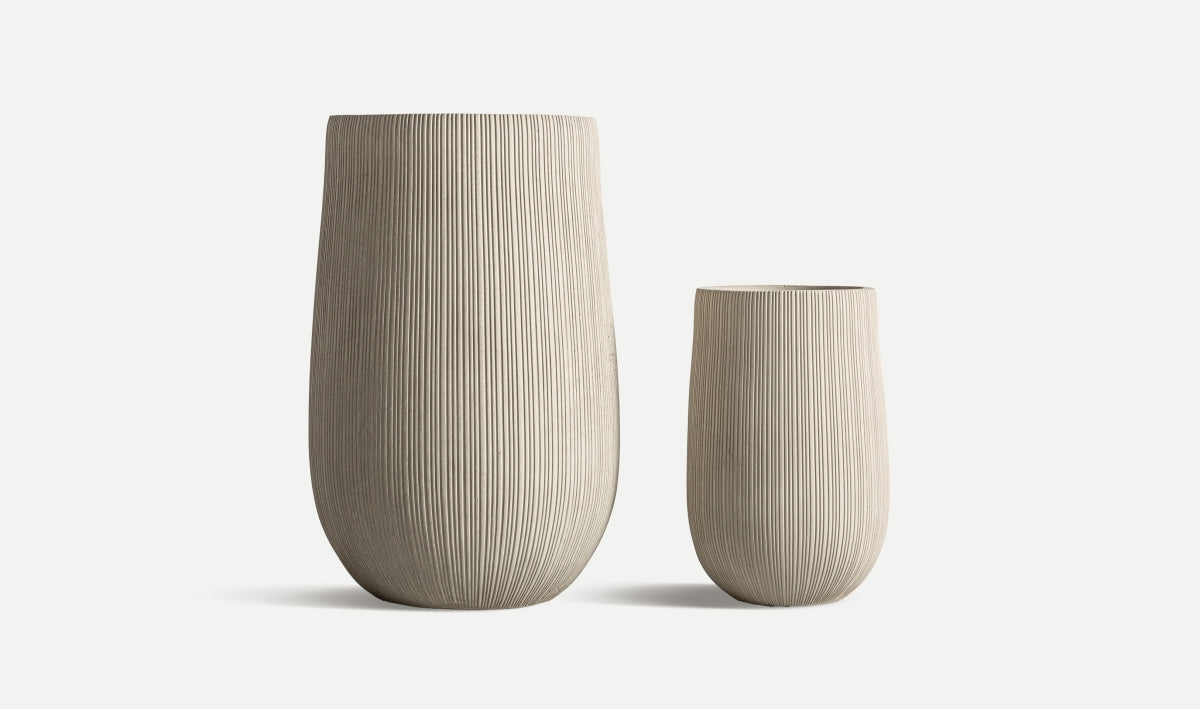 Juego de 2 maceteros de cerámica gris ALYA, uno alto y uno bajo, con líneas verticales y diseño contemporáneo, colocados juntos sobre fondo blanco; ideales para decorar tu hogar.