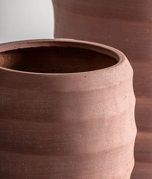 Vista en primer plano del Juego de 2 maceteros de cerámica terracota KORA en acabado natural, con grandes macetas sin esmaltar de superficie rugosa y texturizada y color marrón rojizo.
