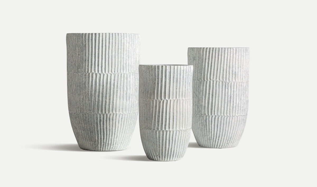 El Juego de 3 maceteros de cerámica gris LUME, en diferentes alturas y acabado natural, se exhibe alineado sobre un fondo blanco.