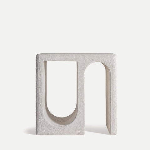 La Mesa Auxiliar en DM blanco minimalista Arnsberg es una escultura minimalista blanca con dos arcos singulares, uno curvo y otro de base cuadrada, que se yerguen elegantemente sobre un fondo liso. Captura la esencia del diseño contemporáneo al fusionar la simplicidad con el arte.