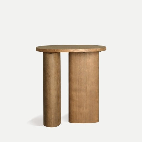 La mesa auxiliar redonda en madera de abeto Hoek1 es una mesa auxiliar moderna con un tablero redondo de madera de abeto, elegantemente sostenido por una pata cilíndrica y otra rectangular.