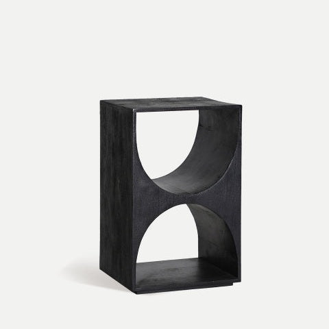 La mesa auxiliar de madera de mango Kirila ofrece una unidad de estante abierto rectangular de color negro hecha de madera de mango con recortes semicirculares en los lados, que se suman a su diseño geométrico y contemporáneo único.