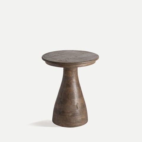 La mesa auxiliar cuadrada de madera de mango Takala, con un diseño de madera robusta, se destaca elegantemente con su base de pedestal cónica sobre un fondo liso.