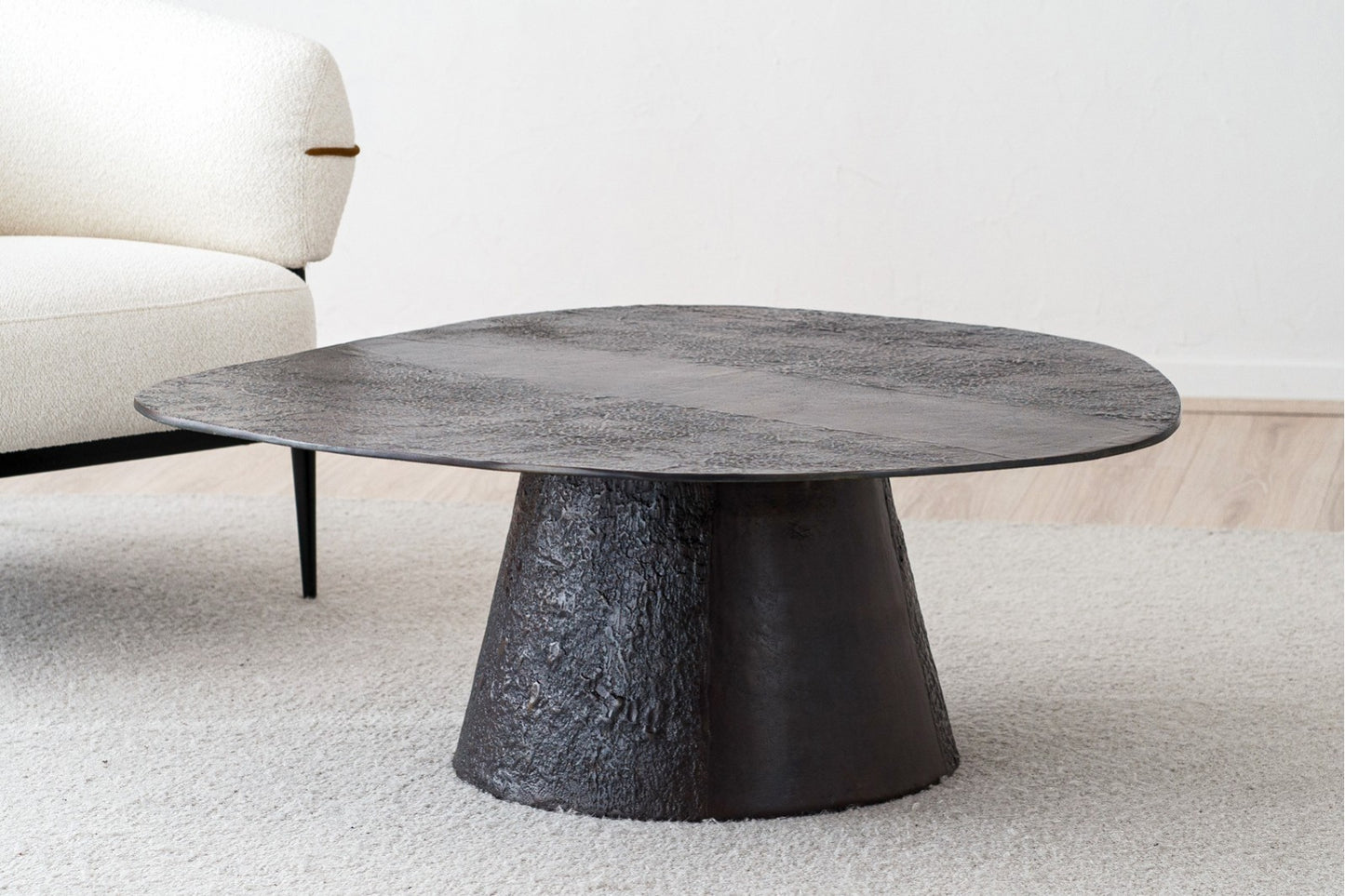 La Mesa de centro redonda de metal JUNO 110×40 CM, con acabado óxido artesanal e inspiración industrial, aporta un toque elegante y moderno sobre la alfombra clara junto al sofá crema.