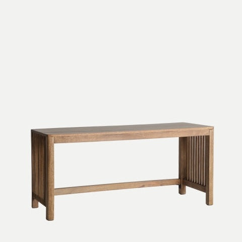 La mesa de centro en madera de mango Trevoux cuenta con un asiento rectangular y lados con listones, elaborados con elegante madera de mango en verdadero estilo nórdico, sobre un fondo gris claro liso.