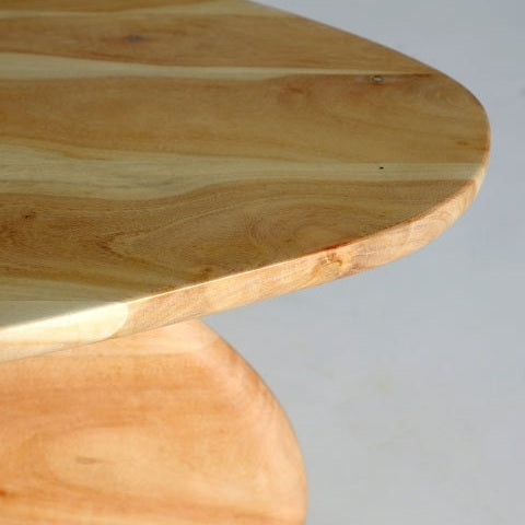 La mesa de centro en madera de acacia Wighill presenta un primer plano de su esquina, elaborada con un acabado suave y natural y suaves curvas que acentúan su veta y diseño contemporáneo.