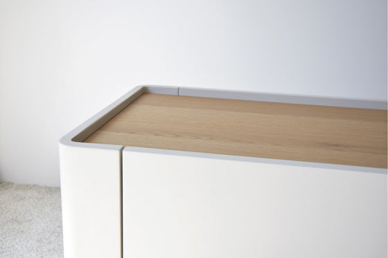 El Mueble TV Arena Mate y Roble Natural - Armonízate, con un acabado blanco minimalista y una cubierta de madera clara en Roble Natural, se destaca elegantemente contra una pared blanca sobre un piso alfombrado claro, incorporando el diseño contemporáneo.