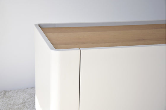 Primer plano de un mueble blanco minimalista con una elegante cubierta de madera, que recuerda al Mueble TV Arena Mate y Roble Natural - Armonízate, sobre un fondo blanco.