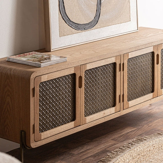 El mueble TV de madera y aluminio Nevoy, elaborado con puertas de paneles de malla de elegante Madera de pino, está bellamente coronado con una obra de arte abstracta enmarcada y una revista sobre un piso de madera.