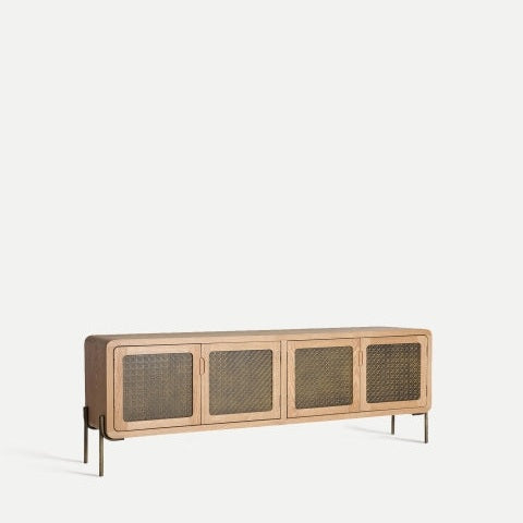 El mueble TV de madera y aluminio Nevoy cuenta con delgadas patas de metal, cuatro puertas con frente de malla y un acabado de madera clara, con una construcción de Madera de pino que agrega un toque natural a su diseño minimalista sobre un fondo blanco liso.