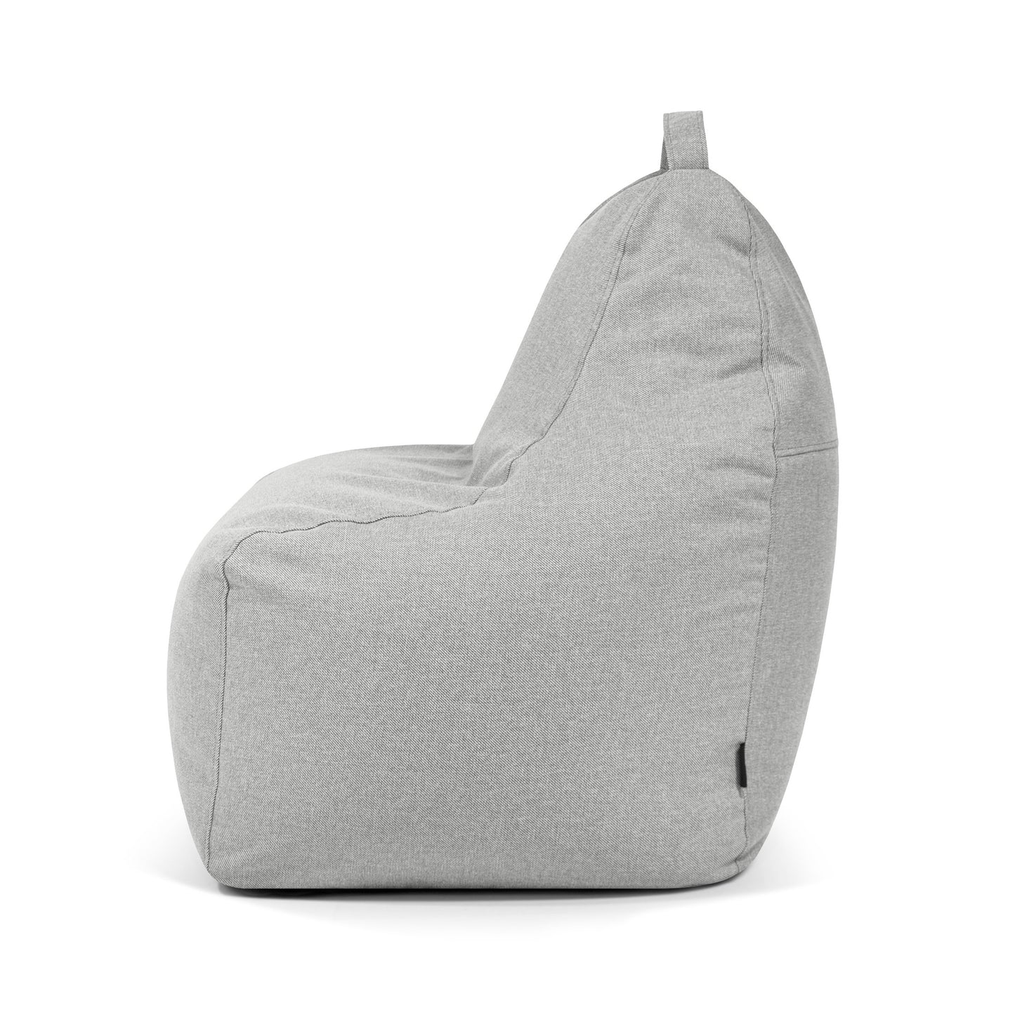 El Bean bag Play Riviera - uso exterior se muestra de lado, con un tejido gris claro, una forma redondeada sencilla, un diseño de puff ergonómico y una pequeña asa en la parte superior.