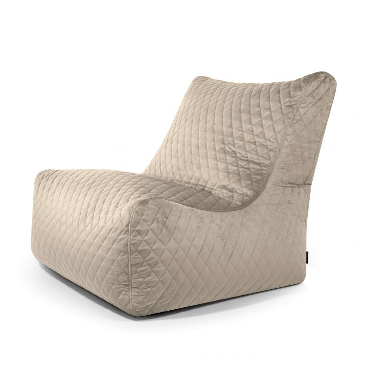 El Bean bag Seat 100 Lure Luxe es un sillón sin brazos acolchado de color beige con asiento y respaldo bajos, que presenta un aspecto suave y acolchado que recuerda a un asiento cómodo o puff ergonómico.