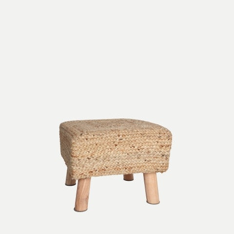 El Puff reposapiés en yute THIESI es un pequeño puf cuadrado que se apoya elegantemente sobre cuatro patas de madera sobre un fondo sencillo, integrándose a la perfección en una decoración moderna al tiempo que proporciona una comodidad innegable.