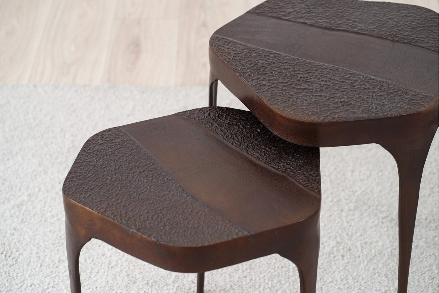 Set de 2 mesas auxiliares redondas de metal con acabado óxido artesanal NAIN, estilo industrial, sobre una alfombra clara junto a un suelo de madera.