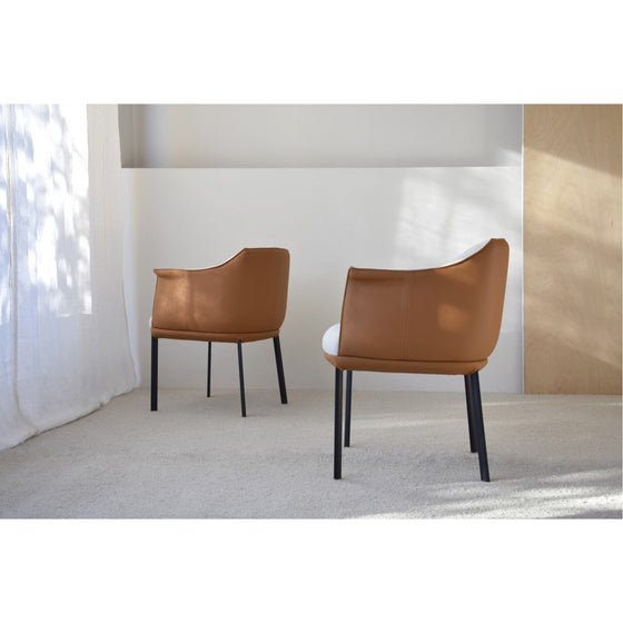 Dos Set 2 Sillas Comedor Brazos Berlín con patas negras, que desprenden elegancia contemporánea, se colocan en una estancia minimalista con luz natural filtrándose a través de cortinas transparentes.