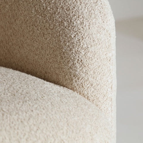 Detalle del Sillón tapizado en bouclé crema Privas, destacando su textura beige claro bouclé crema y su elegante respaldo curvado.